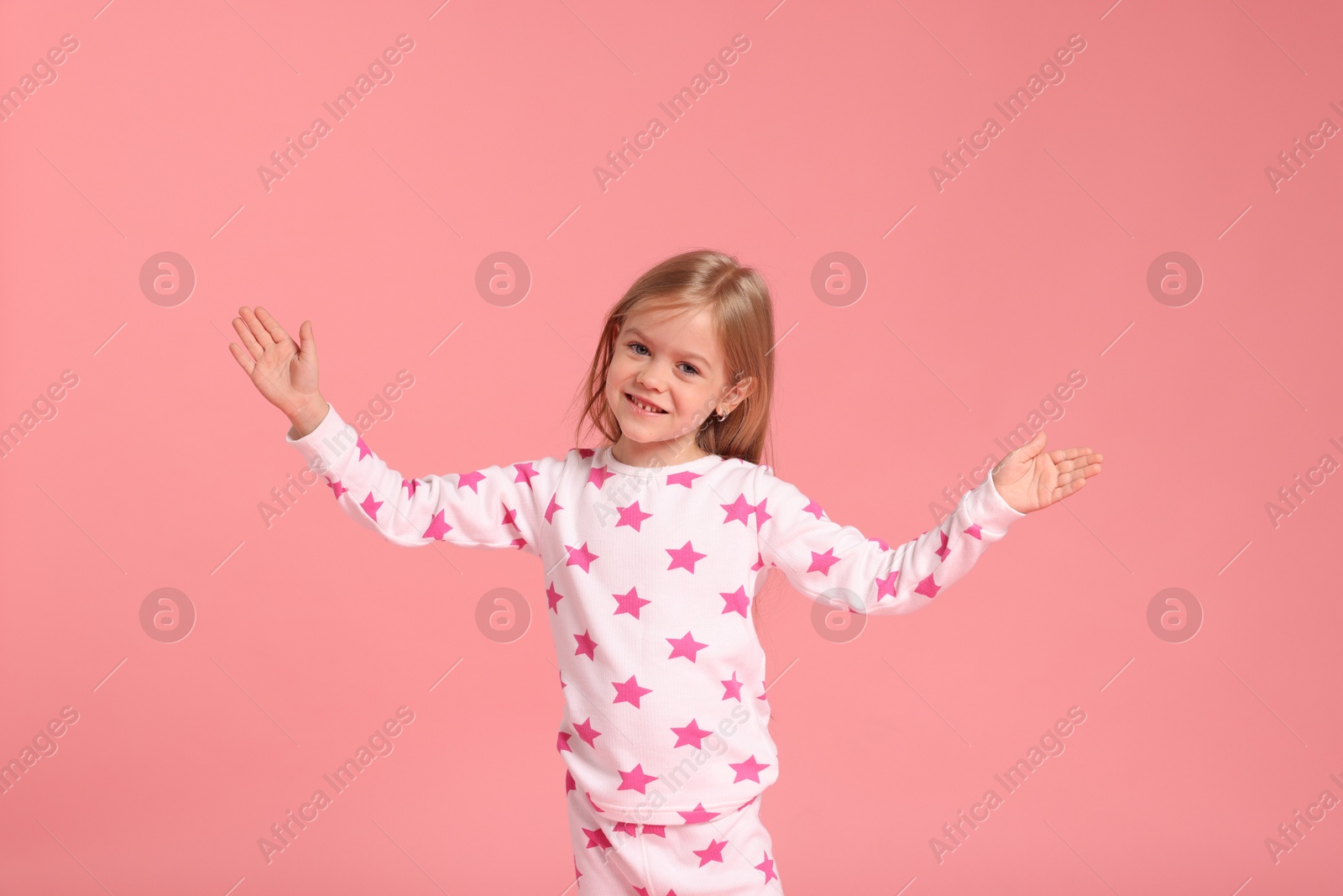 Cute little girl in pajamas on pink background Photo of Cute little girl in pajamas on pink background