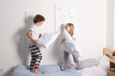 Photo of Happy children having fun on bed at home