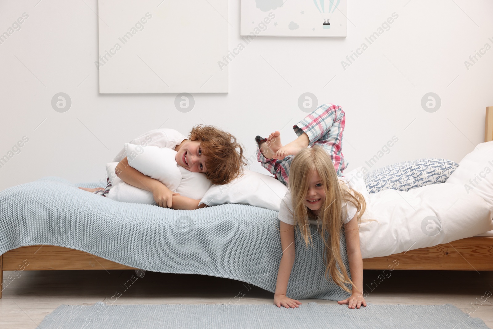 Photo of Happy children having fun on bed at home