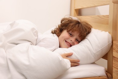 Photo of Little boy lying in bed at home