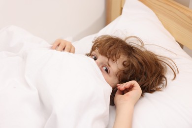 Photo of Little boy lying in bed at home