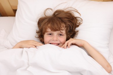 Photo of Little boy lying in bed at home
