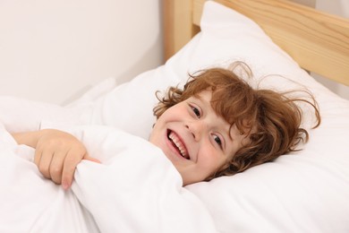 Photo of Little boy lying in bed at home