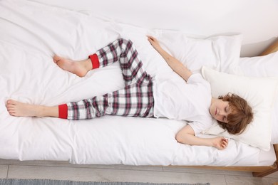 Photo of Little boy sleeping in bed at home, above view