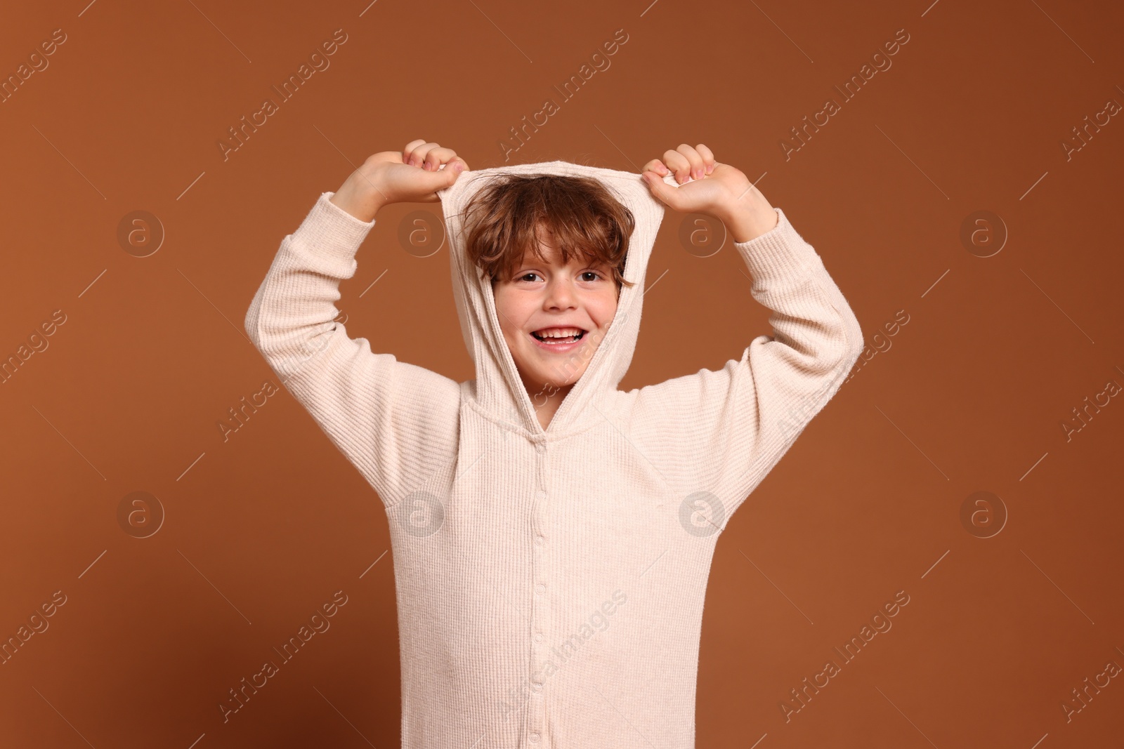 Cute little boy in pajamas on brown background Photo of Cute little boy in pajamas on brown background