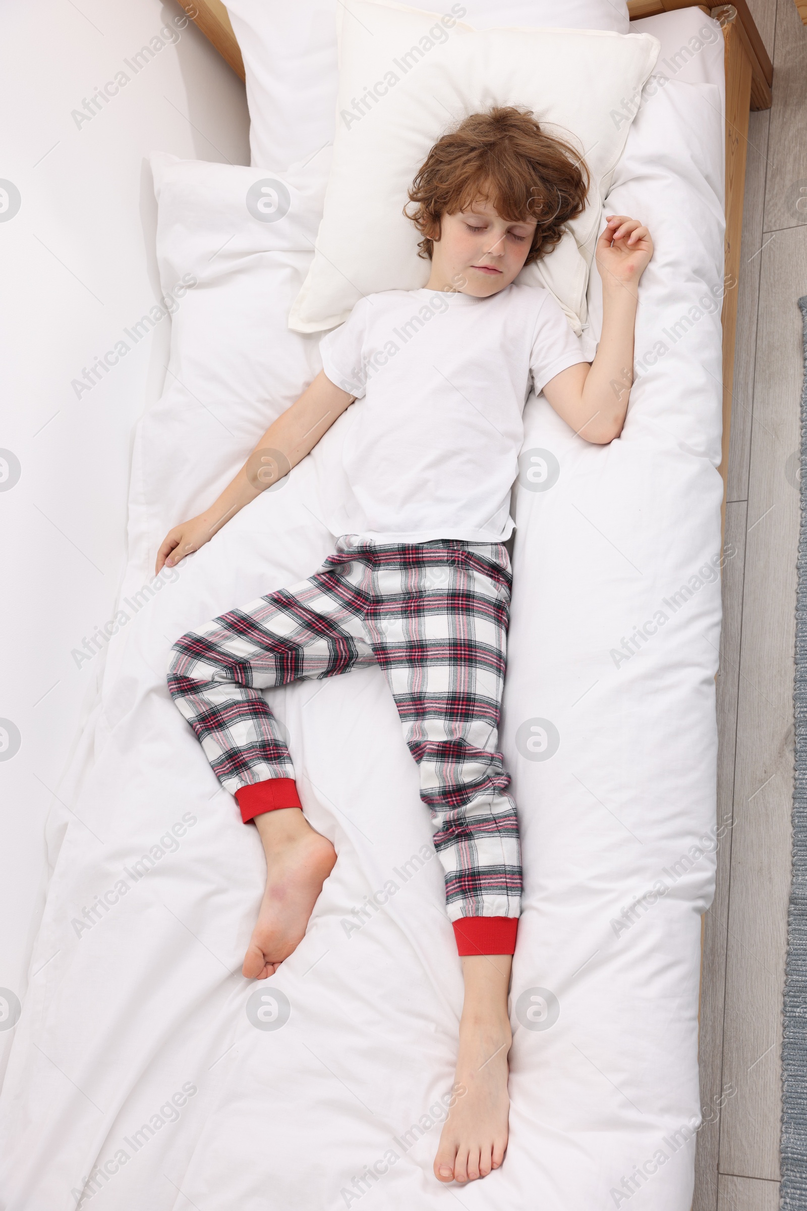 Cute little boy sleeping on bed at home, top view Photo of Cute little boy sleeping on bed at home, top view