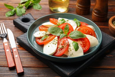 Photo of Tasty salad Caprese served on wooden table, closeup