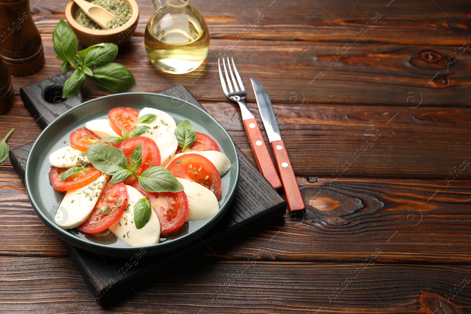 Tasty salad Caprese served on wooden table. Space for text Photo of Tasty salad Caprese served on wooden table. Space for text
