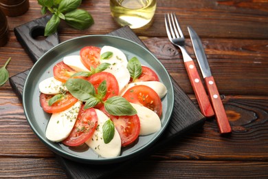 Photo of Tasty salad Caprese served on wooden table, closeup