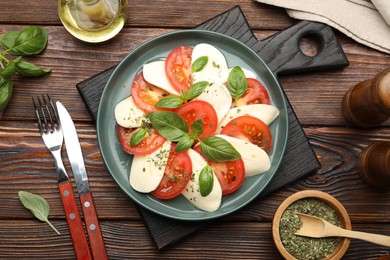 Photo of Tasty salad Caprese served on wooden table, flat lay