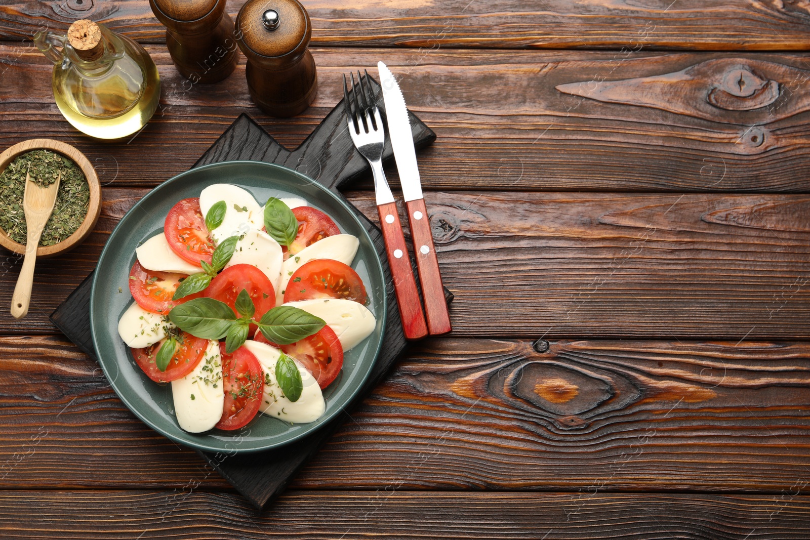 Tasty salad Caprese served on wooden table, flat lay. Space for text Photo of Tasty salad Caprese served on wooden table, flat lay. Space for text