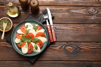 Photo of Tasty salad Caprese served on wooden table, flat lay. Space for text