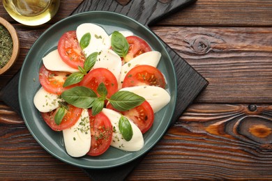 Photo of Tasty salad Caprese served on wooden table, flat lay. Space for text