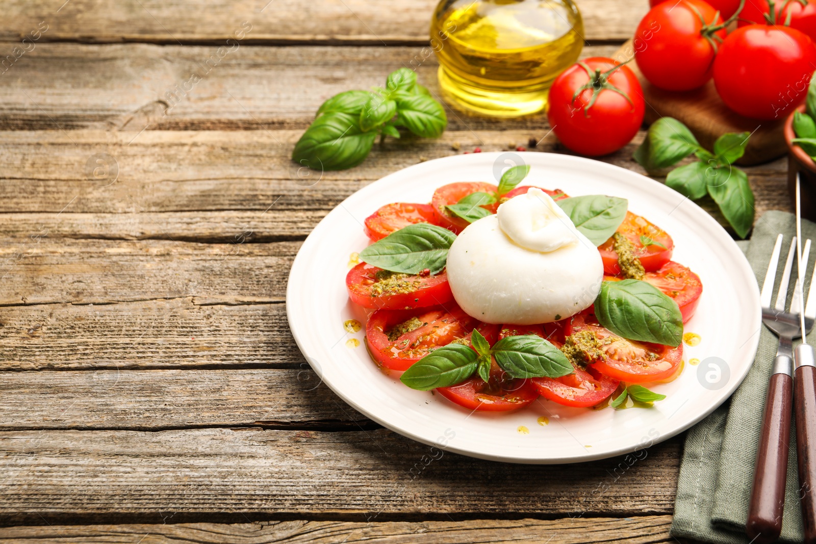 Tasty salad Caprese served with pesto sauce on wooden table, closeup. Space for text Photo of Tasty salad Caprese served with pesto sauce on wooden table, closeup. Space for text