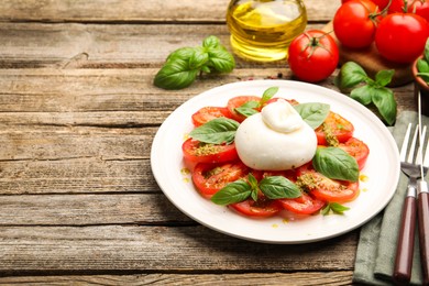 Photo of Tasty salad Caprese served with pesto sauce on wooden table, closeup. Space for text
