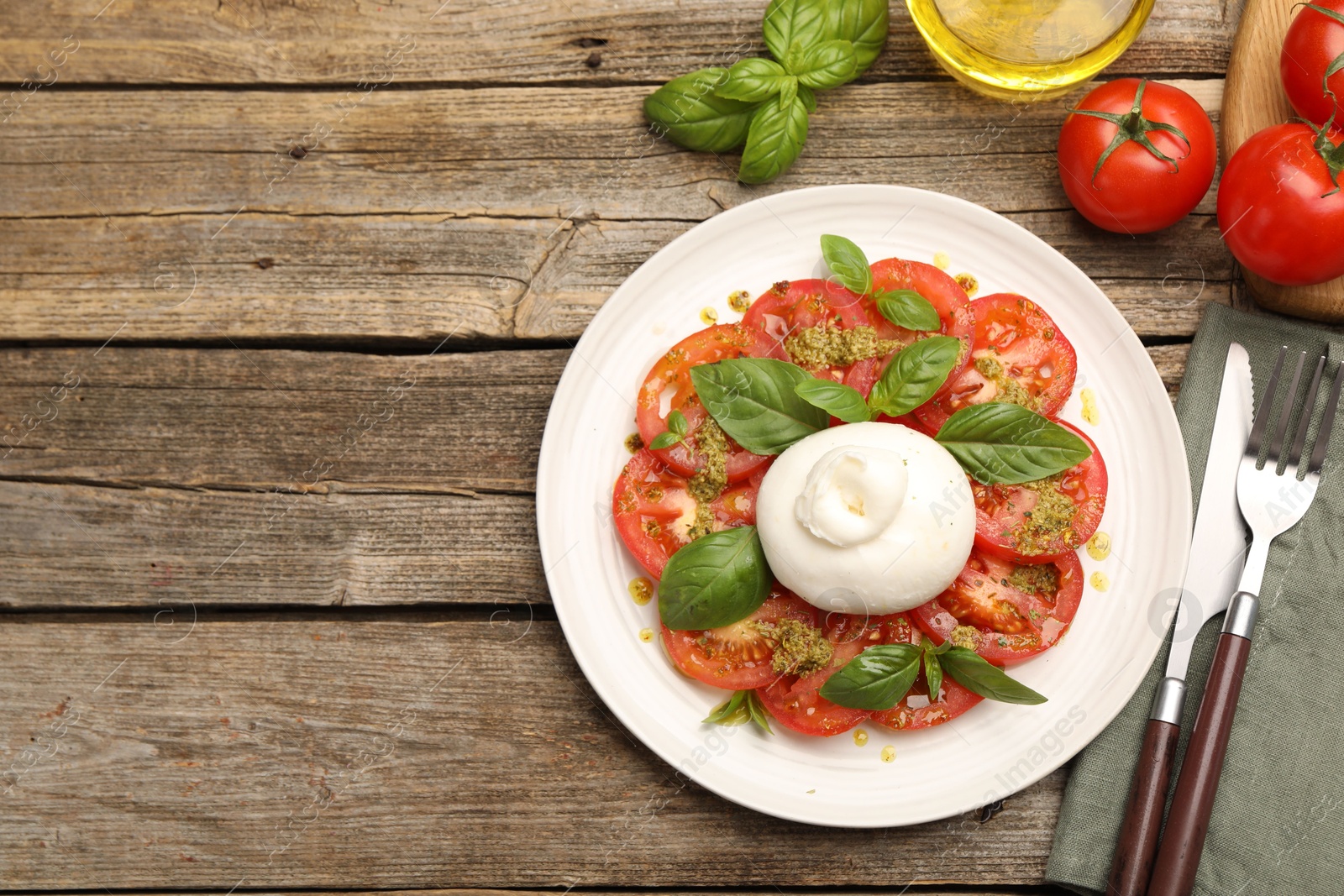 Tasty salad Caprese served with pesto sauce on wooden table, flat lay. Space for text Photo of Tasty salad Caprese served with pesto sauce on wooden table, flat lay. Space for text