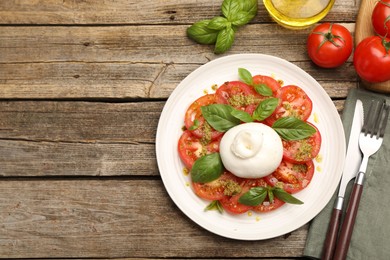 Photo of Tasty salad Caprese served with pesto sauce on wooden table, flat lay. Space for text