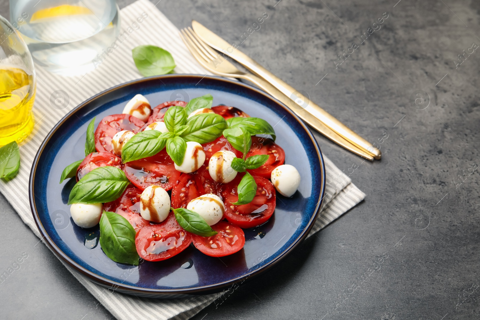 Tasty salad Caprese served with balsamic vinegar on grey table, closeup. Space for text Photo of Tasty salad Caprese served with balsamic vinegar on grey table, closeup. Space for text