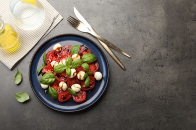 Photo of Tasty salad Caprese served with balsamic vinegar on grey table, flat lay. Space for text