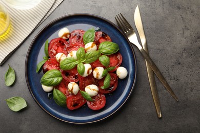 Photo of Tasty salad Caprese served with balsamic vinegar on grey table, flat lay