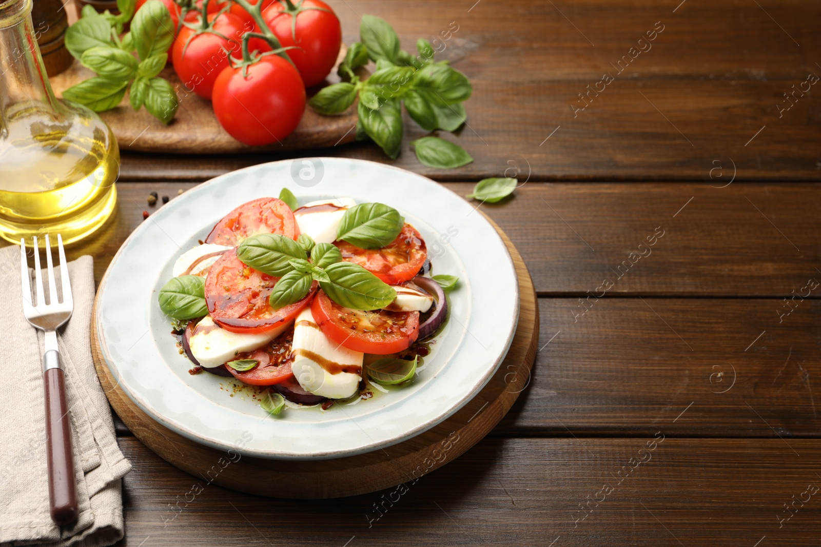 Tasty salad Caprese with mozzarella, tomatoes, basil and spices on wooden table, closeup. Space for text Photo of Tasty salad Caprese with mozzarella, tomatoes, basil and spices on wooden table, closeup. Space for text