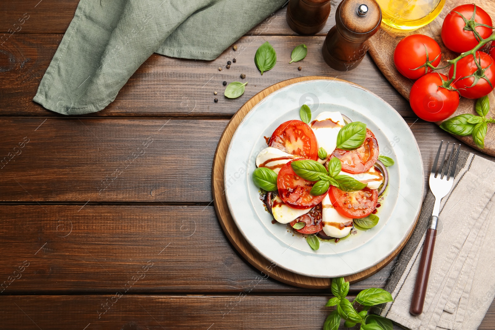 Tasty salad Caprese served with balsamic vinegar on wooden table, flat lay. Space for text Photo of Tasty salad Caprese served with balsamic vinegar on wooden table, flat lay. Space for text