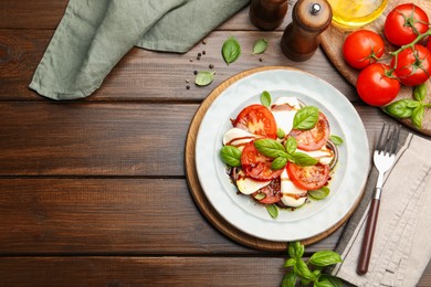 Photo of Tasty salad Caprese served with balsamic vinegar on wooden table, flat lay. Space for text