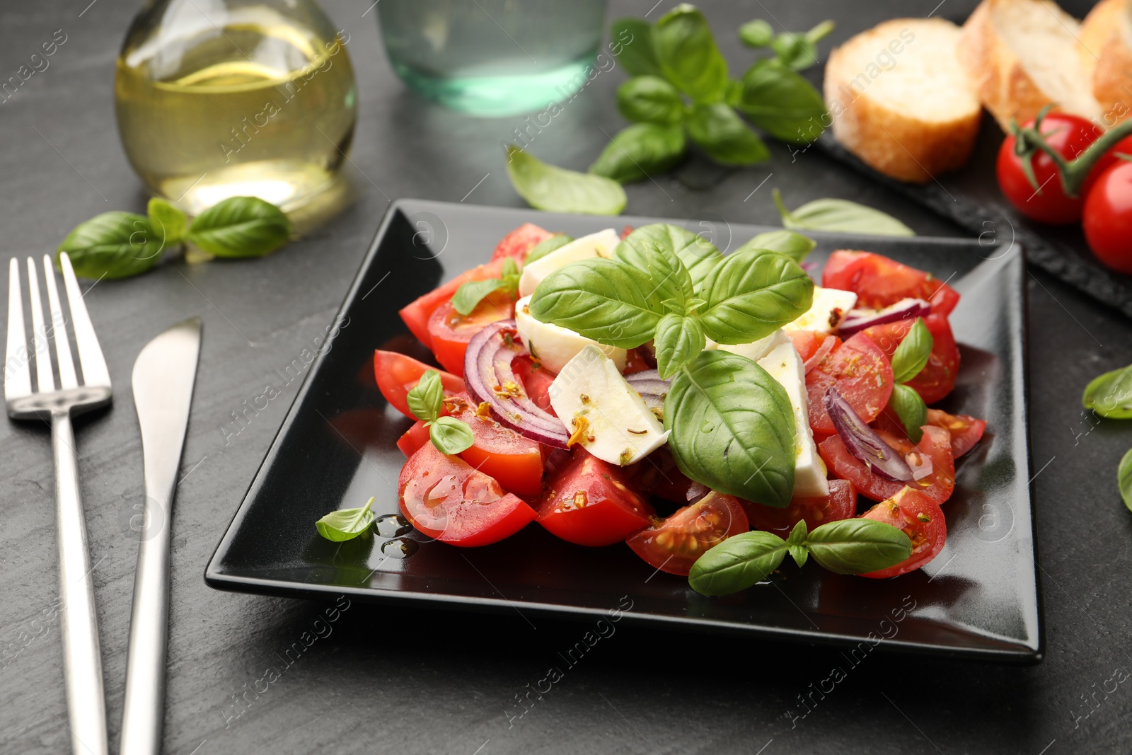 Tasty salad Caprese served on black table, closeup Photo of Tasty salad Caprese served on black table, closeup