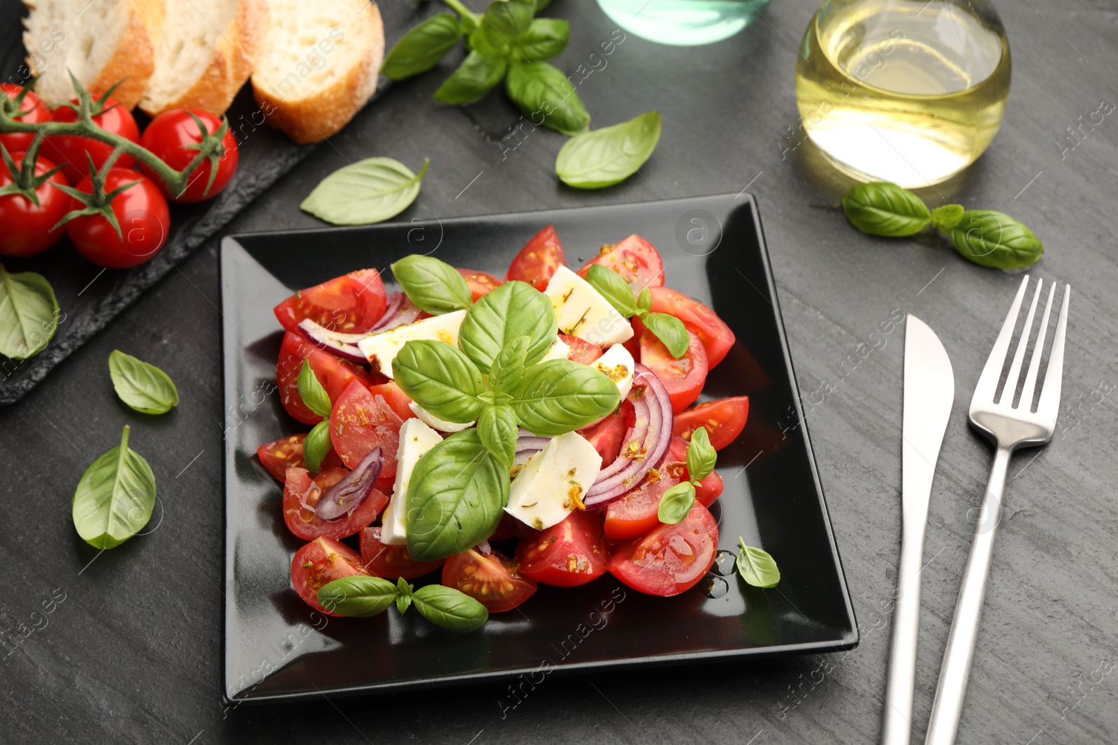 Tasty salad Caprese served on black table, above view Photo of Tasty salad Caprese served on black table, above view