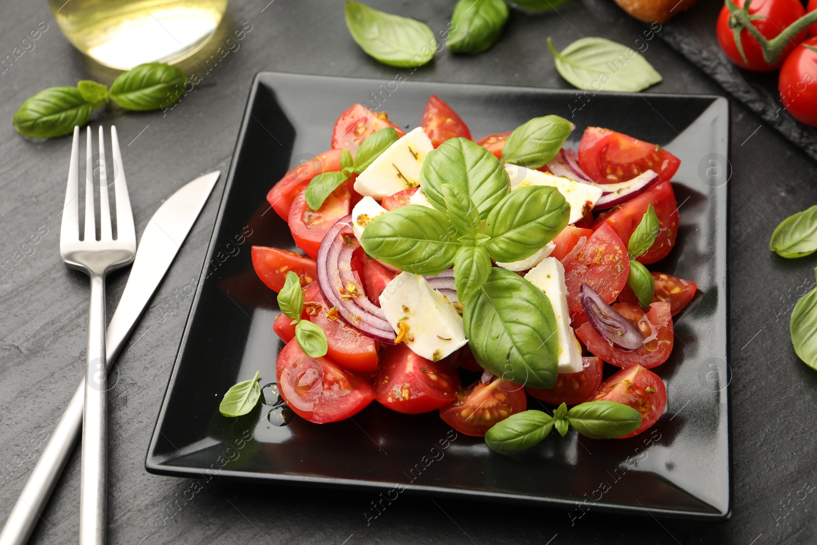 Tasty salad Caprese served on black table, closeup Photo of Tasty salad Caprese served on black table, closeup