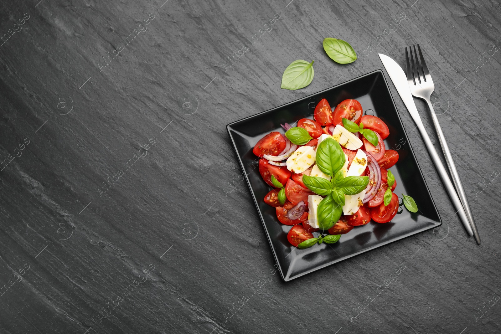 Tasty salad Caprese served on black table, flat lay. Space for text Photo of Tasty salad Caprese served on black table, flat lay. Space for text