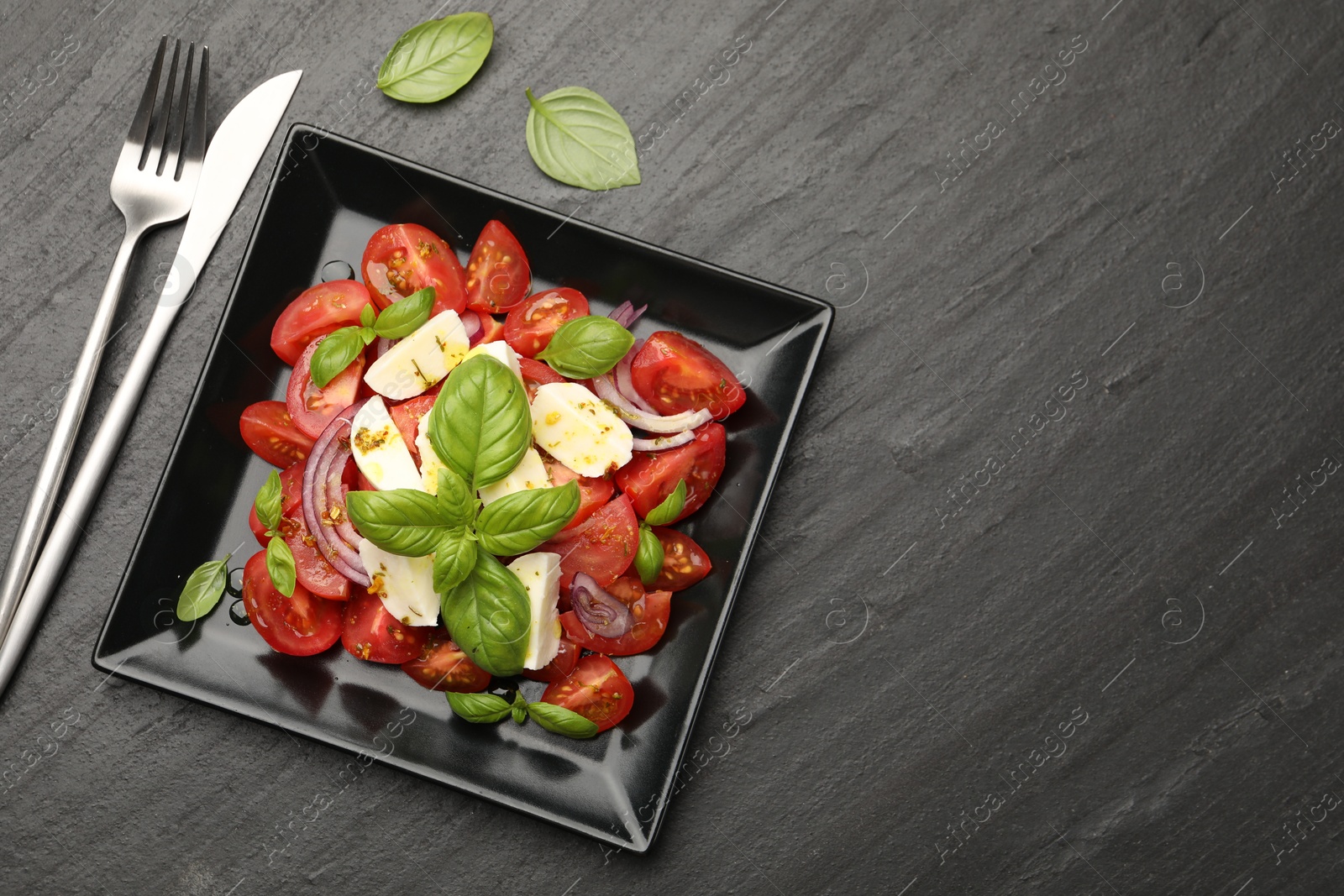 Tasty salad Caprese served on black table, flat lay. Space for text Photo of Tasty salad Caprese served on black table, flat lay. Space for text