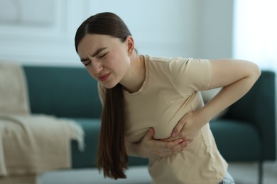 Photo of Woman suffering from chest pain at home