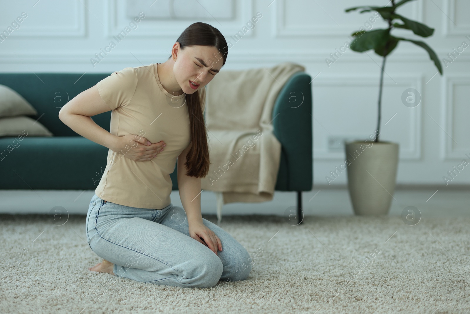 Photo of Woman suffering from chest pain at home, space for text