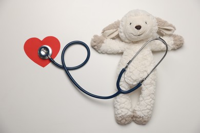 Photo of Pediatrics concept. Toy sheep with stethoscope on white background, top view