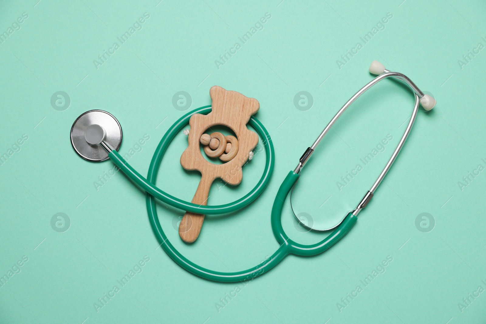 Photo of Pediatrics concept. Stethoscope and toy on turquoise background, top view