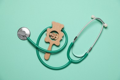 Photo of Pediatrics concept. Stethoscope and toy on turquoise background, top view