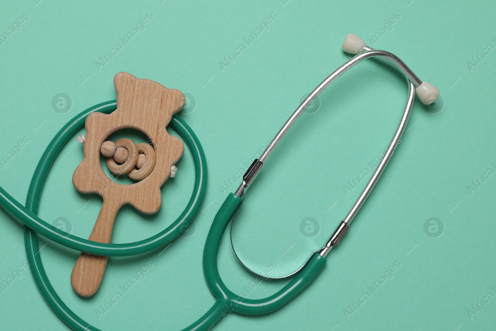 Photo of Pediatrics concept. Stethoscope and toy on turquoise background, top view