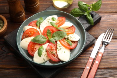 Photo of Tasty salad Caprese served on wooden table, closeup