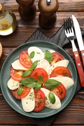 Photo of Tasty salad Caprese served on wooden table, flat lay