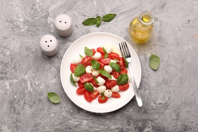 Photo of Tasty salad Caprese served on grey table, flat lay