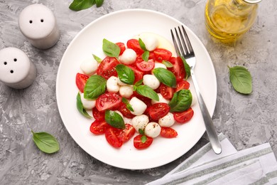Photo of Tasty salad Caprese served on grey table, flat lay