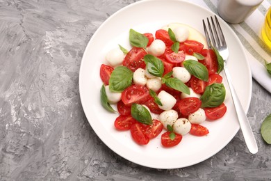 Photo of Tasty salad Caprese served on grey table, top view. Space for text