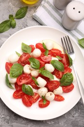 Photo of Tasty salad Caprese served on grey table, flat lay
