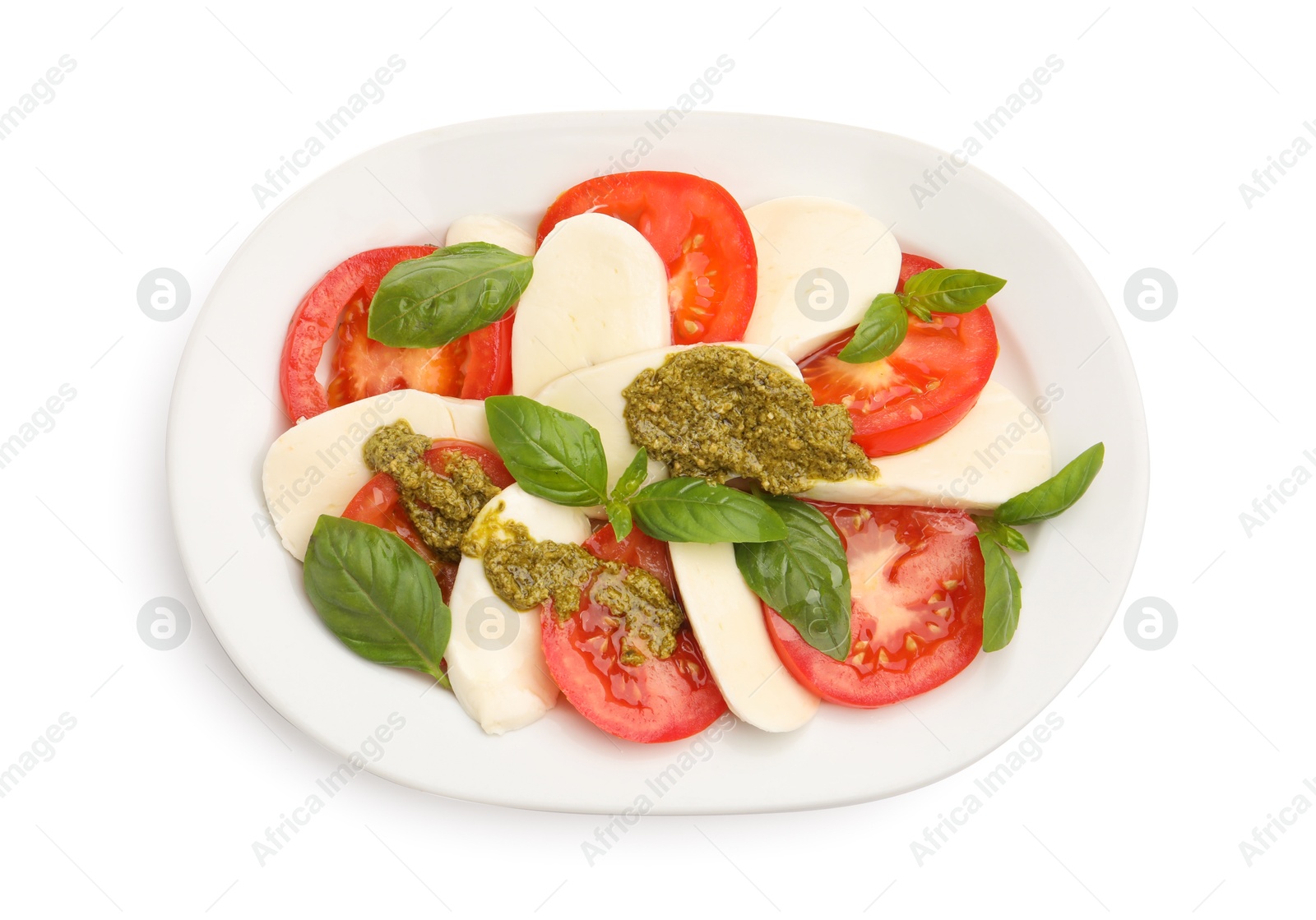Photo of Tasty salad Caprese with mozzarella, tomatoes, basil and pesto sauce isolated on white, top view