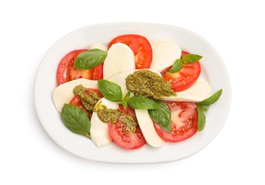 Photo of Tasty salad Caprese with mozzarella, tomatoes, basil and pesto sauce isolated on white, top view
