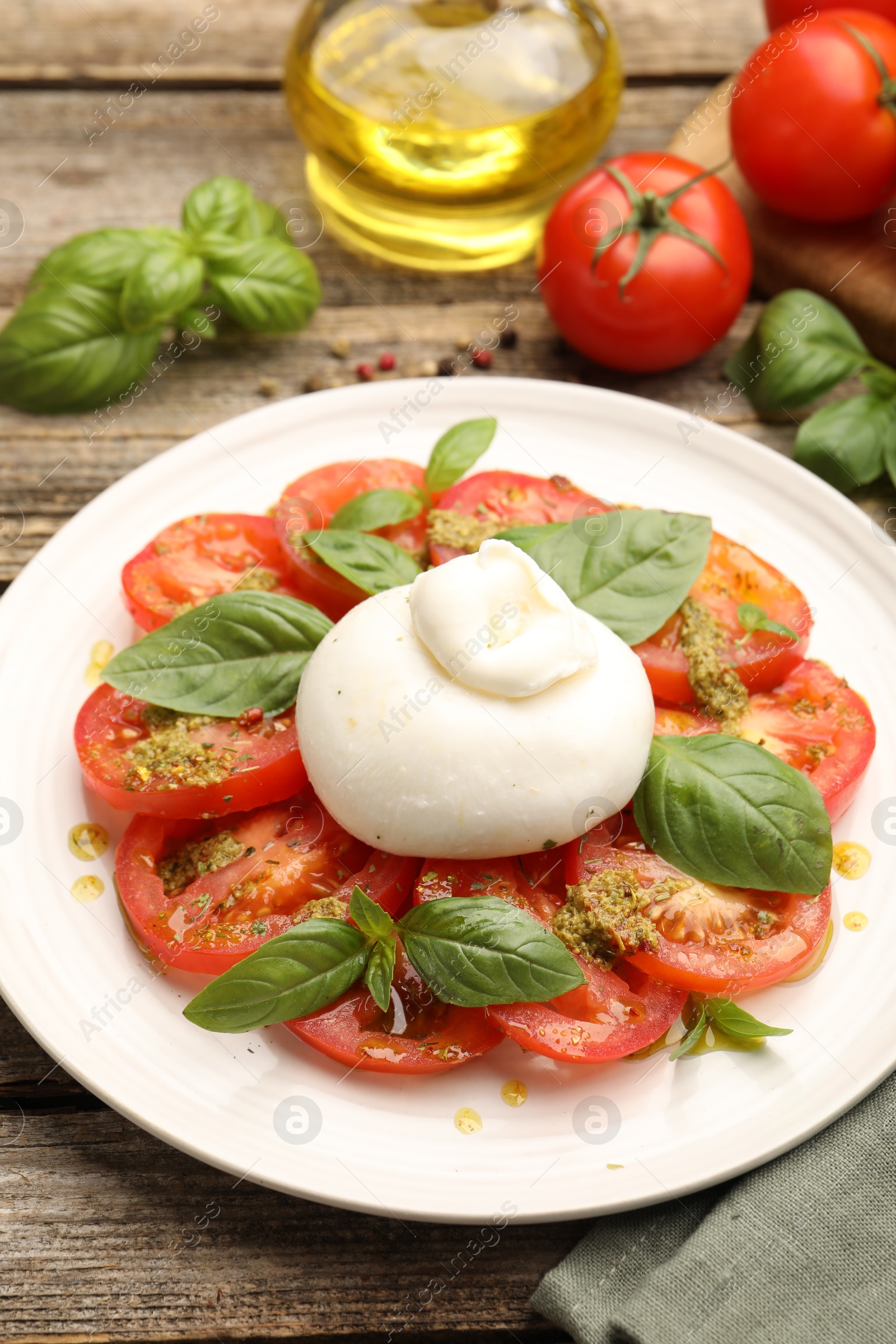Tasty salad Caprese served with pesto sauce on wooden table, closeup Photo of Tasty salad Caprese served with pesto sauce on wooden table, closeup