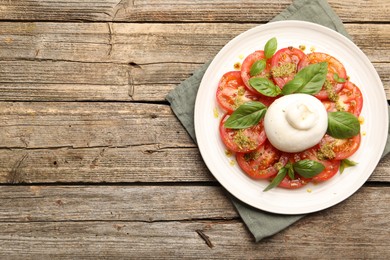 Photo of Tasty salad Caprese with mozzarella, tomatoes, basil and pesto sauce on wooden table, top view. Space for text