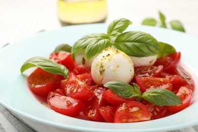 Photo of Tasty salad Caprese with mozzarella, tomatoes, basil and spices on table, closeup