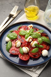 Photo of Tasty salad Caprese served with balsamic vinegar on grey table, closeup